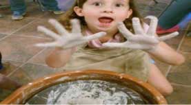 Girl with clay looking surprised.